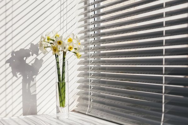 Persiana shangri-La con florero de flores blancas